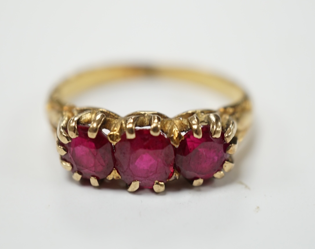 A yellow metal and three stone synthetic ruby set ring, size M, gross weight 4.8 grams. Condition - fair